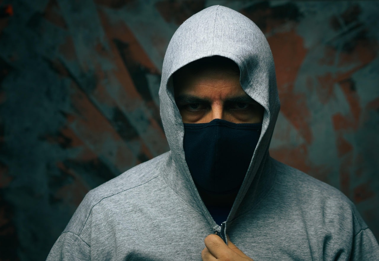 Un homme avec masque et capuche représentant un agresseur non-identifié